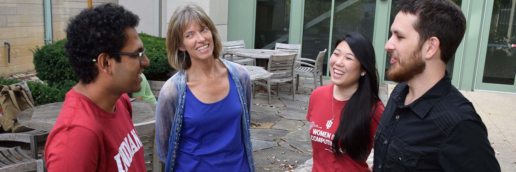 Data science professor speaks to students as they gather outside in a circle to talk.